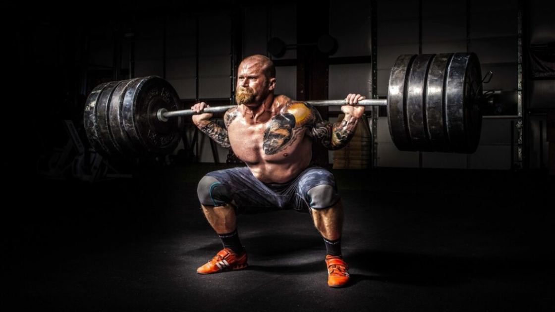 The physics of how Olympic weightlifters exploit barbell's "whip"